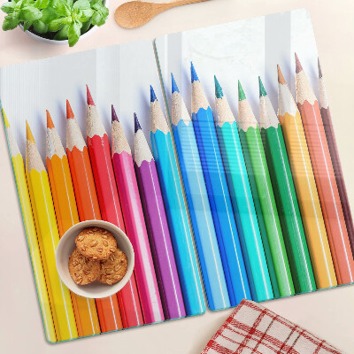 Glass chopping board Colored pencils in a row