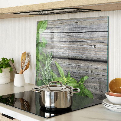 Glass chopping board Green herbs on wooden background