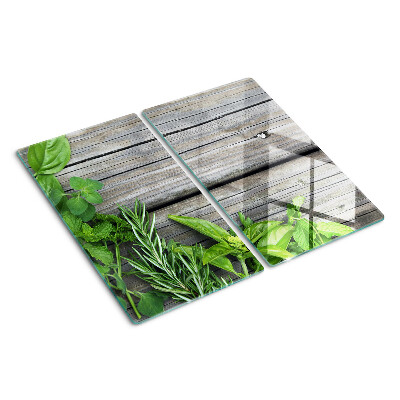 Glass chopping board Green herbs on wooden background