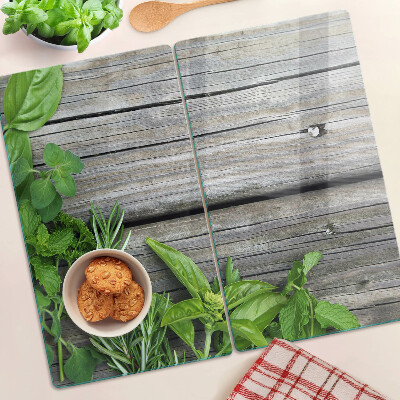 Glass chopping board Green herbs on wooden background