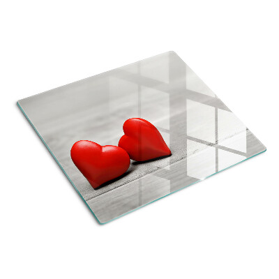 Glass chopping board Red hearts on a wooden background