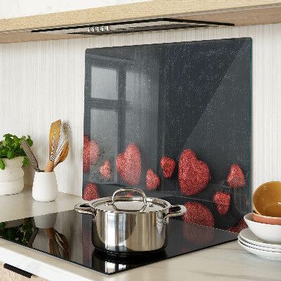 Glass kitchen board Red hearts on a dark background