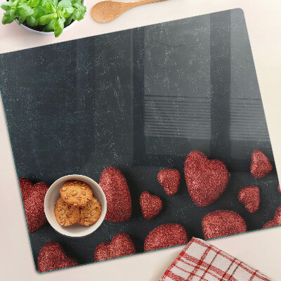 Glass kitchen board Red hearts on a dark background