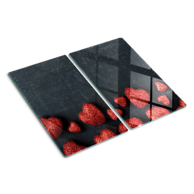 Glass kitchen board Red hearts on a dark background