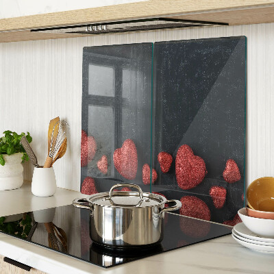 Glass kitchen board Red hearts on a dark background