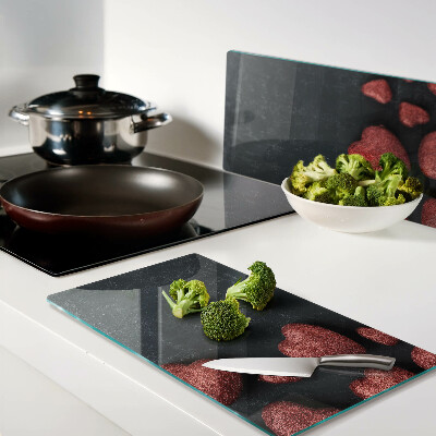 Glass kitchen board Red hearts on a dark background