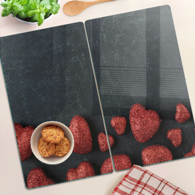 Glass kitchen board Red hearts on a dark background
