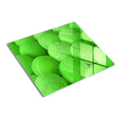 Glass chopping board Tennis balls on a green background