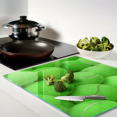 Glass chopping board Tennis balls on a green background