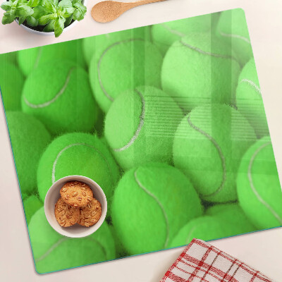 Glass chopping board Tennis balls on a green background