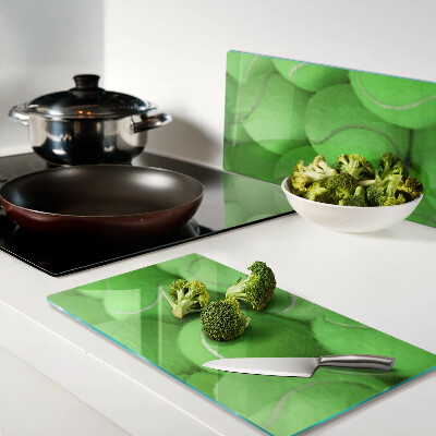 Glass chopping board Tennis balls on a green background