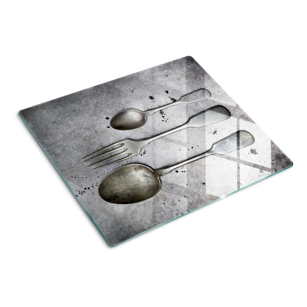 Glass chopping board Cutlery on a concrete background
