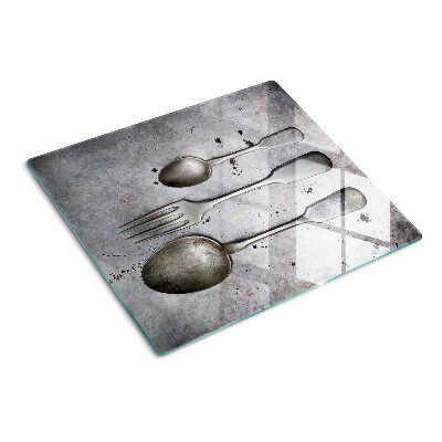 Glass chopping board Cutlery on a concrete background