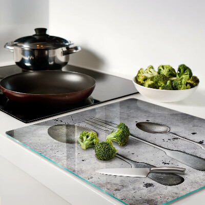 Glass chopping board Cutlery on a concrete background