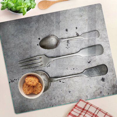 Glass chopping board Cutlery on a concrete background