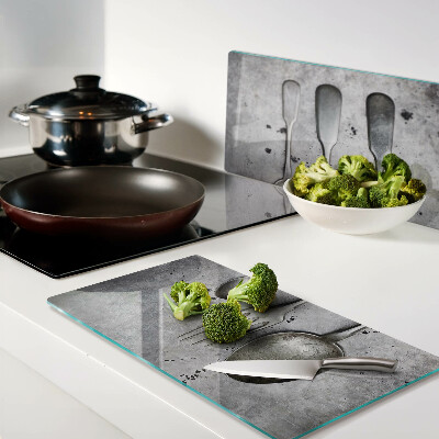 Glass chopping board Cutlery on a concrete background
