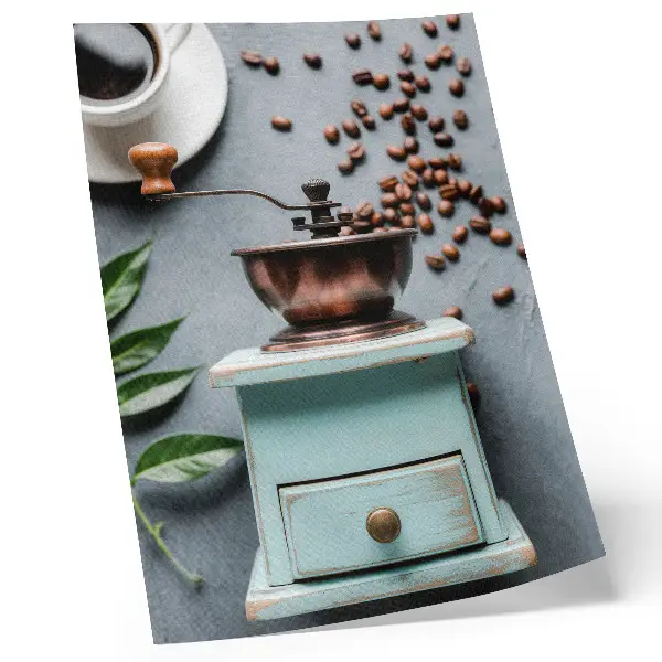 Decorative poster featuring an old turquoise coffee grinder with coffee beans and green leaves