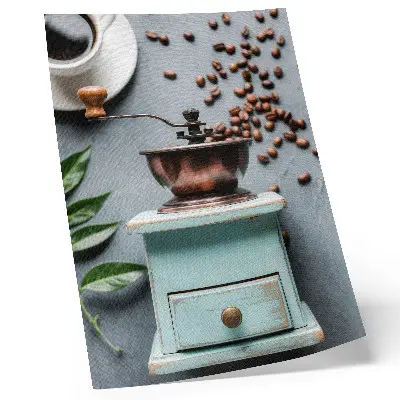 Decorative poster featuring an old turquoise coffee grinder with coffee beans and green leaves