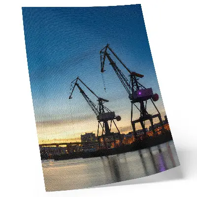 Poster cranes against a dynamic sunset backdrop