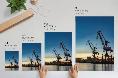 Poster cranes against a dynamic sunset backdrop