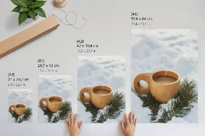 Decorative poster with a snowy landscape and green twigs on a wooden mug