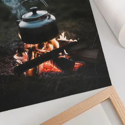 Decorative poster kettle over a fire in the forest by the lake