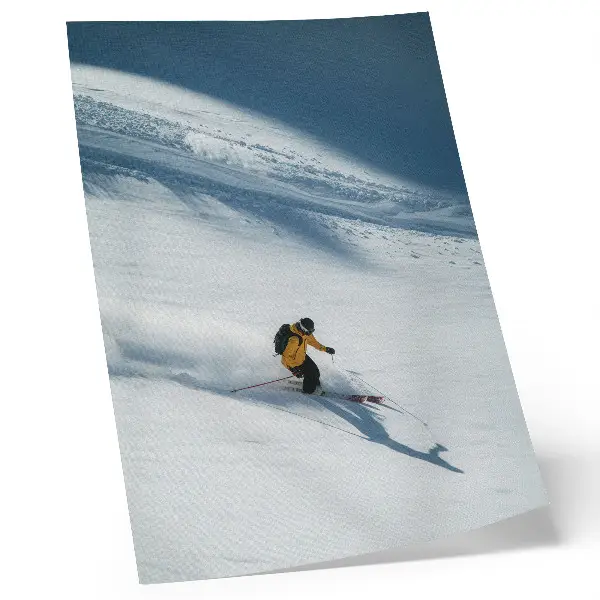 Poster skier in a yellow jacket on a snowy slope with shadow