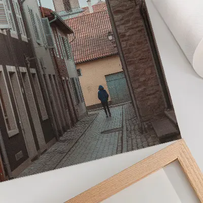 Poster narrow street with tenement houses and a tower with a blue coat
