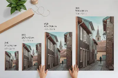 Poster narrow street with tenement houses and a tower with a blue coat