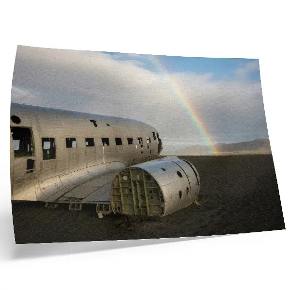 Decorative canvas print featuring a metal plane wreck with a rainbow in the background