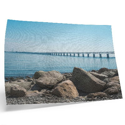 Decorative canvas print Bridge over blue water stones on the shore