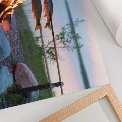Decorative canvas print featuring a bonfire by the lake with fish on sticks
