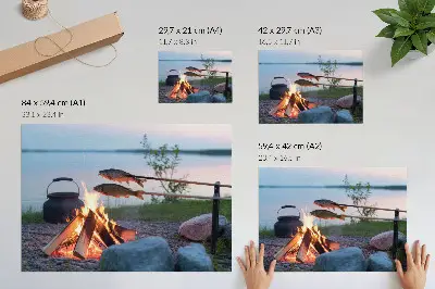 Decorative canvas print featuring a bonfire by the lake with fish on sticks