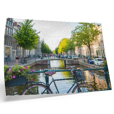Photo canvas view of a canal with a bridge, trees, buildings, bicycle, and flowers