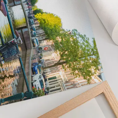 Photo canvas view of a canal with a bridge, trees, buildings, bicycle, and flowers