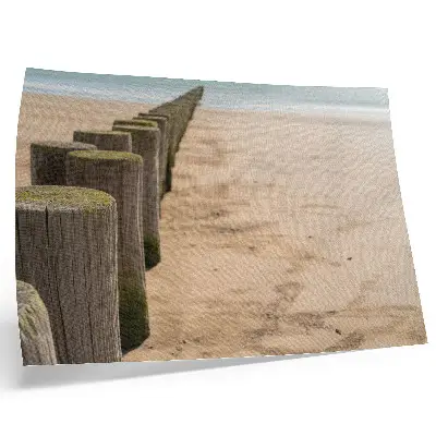 Decorative canvas print featuring wooden stakes on a peaceful beach