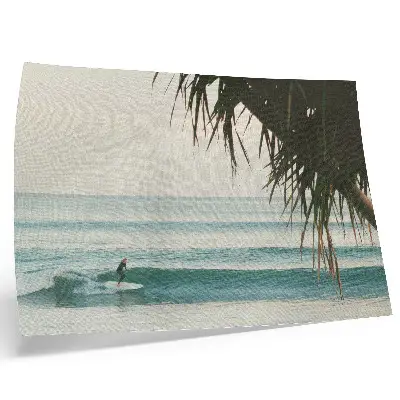 Decorative canvas print featuring a peaceful beach scene with surfing waves and palm trees
