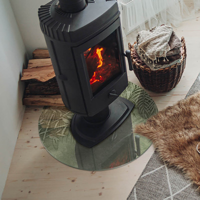 Glass hearth for stove round Tropical leaves in the background