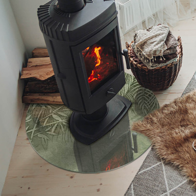 Glass hearth for stove round Tropical leaves in the background