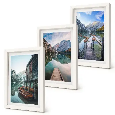 A quiet lake in the mountains with wooden boats framed triptych
