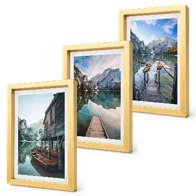A quiet lake in the mountains with wooden boats framed triptych