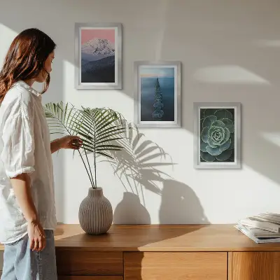 Framed triptych mountains with a pink sky, water, and green succulents