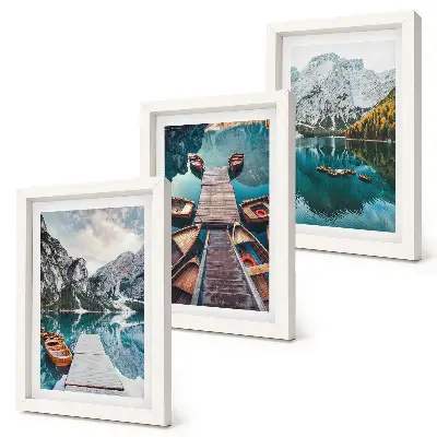 A lake with wooden piers and mountains framed triptych