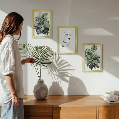 Photo frame wall with green tropical leaves and decorative inscription
