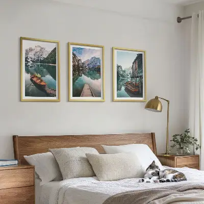 Set of 3 framed wall art pieces featuring a lake with mountains, boats, and a cottage